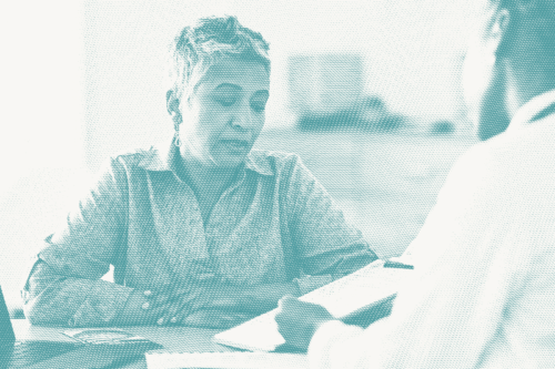 a woman speaks with her doctor; illustrative of a conversation about breast cancer recurrence