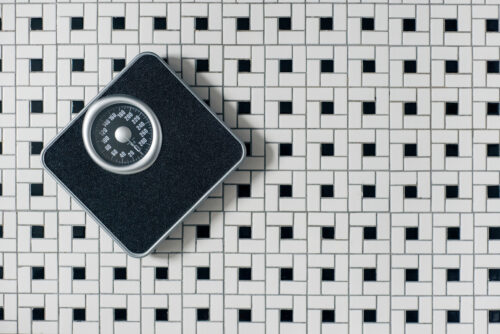 A bathroom scale on a tiled floor